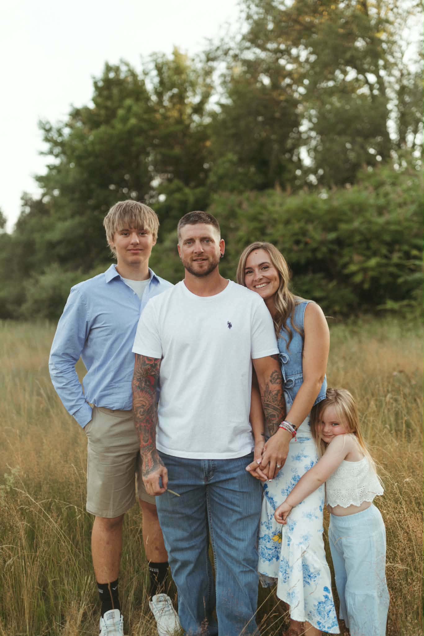 A family of four standing together outdoors